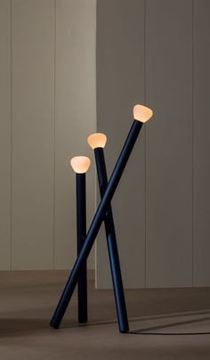 three black and white lamps sitting next to each other on top of a wooden floor