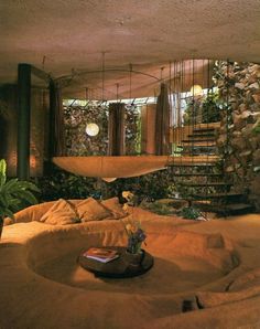 a living room filled with lots of furniture next to a spiral stair case in front of a window