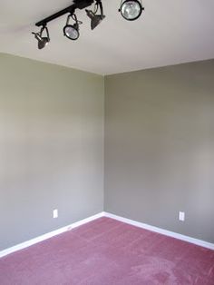 an empty room with three lights on the ceiling