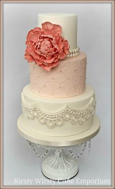 a three tiered cake with pink flowers on top