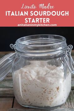 a glass jar filled with food sitting on top of a wooden table next to a spoon