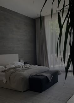 a large bed sitting in the middle of a bedroom next to a tall window with curtains