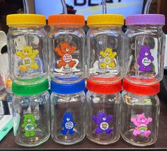 there are many different colored bears in the glass jars