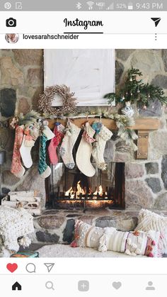 a fireplace with stockings hanging from it's mantle next to pillows and other decorations