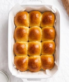 bread rolls in a white baking dish on a table