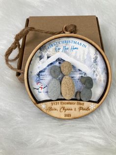 a christmas ornament with three pebbles on it in a wooden box