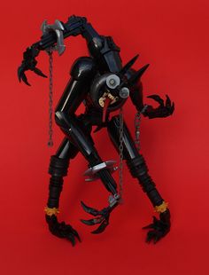 an action figure is posed on a red background with chains and claws attached to it