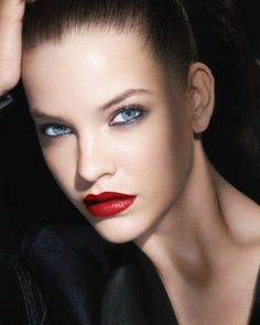 a woman with blue eyes and red lipstick is posing for a magazine cover photo shoot