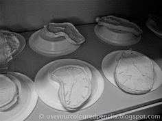 four plates with food on them sitting on top of an oven burner in black and white