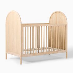 a small wooden crib with no mattress on the bottom and side rails, in front of a white background