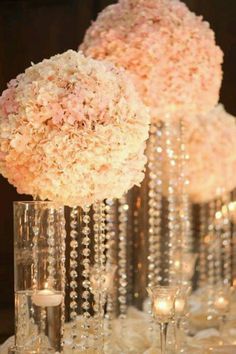 flowers are in vases with crystal beads on the bottom, and one is filled with water