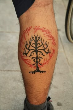 a man's leg with a tree tattoo on it