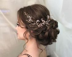 a woman wearing a bridal hair comb with flowers on it's head and pearls in her hair