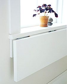 a white radiator in front of a window next to a potted plant