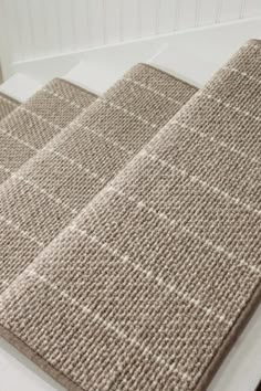 a close up view of a rug on the floor in a bathroom with white walls