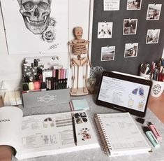 an open book sitting on top of a desk next to a laptop and other items