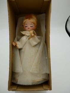 a doll in a cardboard box on a table