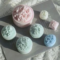 there are six cupcakes with flowers on the top and one is pink, blue, and white