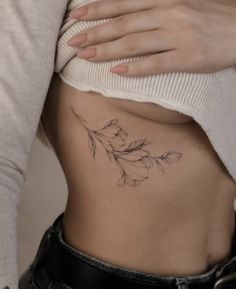 a woman's stomach with a flower tattoo on it