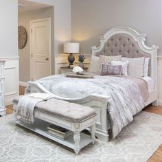 a bedroom with a bed, dressers and mirror in it's center area