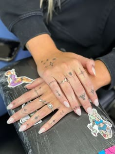 a woman's hands with tattoos on them and her hand resting on a suitcase