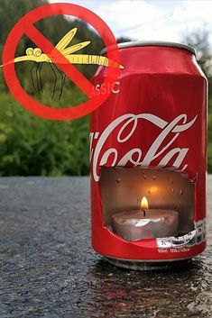 a can of coca - cola sitting on top of a table next to a candle