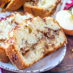 two slices of apple bread on a plate with an apple in the background and one slice cut out