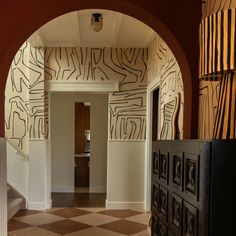 an archway leading into a hallway with decorative wallpaper on the walls and flooring