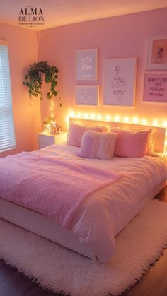 a pink bedroom with lights on the headboard and bed in front of a window