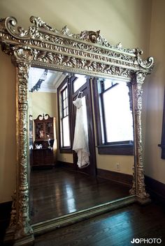 a large mirror with a wedding dress hanging on it