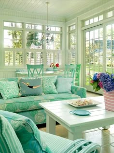 a living room filled with lots of furniture and flowers in vases on the table