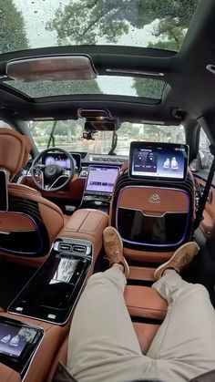 the interior of a luxury car with electronic devices in the passenger's seats and onlookers