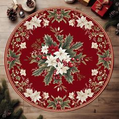 a christmas themed round rug with holly and white flowers on a wooden floor surrounded by presents