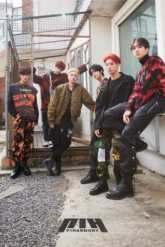 group of young men standing next to each other in front of a building with stairs