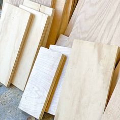 several pieces of wood sitting on the ground next to each other in front of some boards