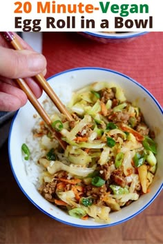 a person holding chopsticks over a bowl of food with rice and vegetables in it