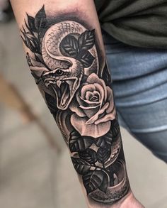 a man's arm with a snake and roses tattoo design on it, in black and white