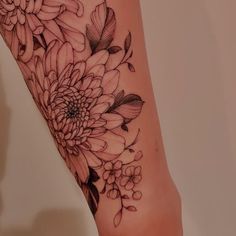 a black and white flower tattoo on the left leg, with flowers in it's center