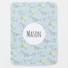 a blue notebook with green dinosaurs on it and the word mason written in black ink