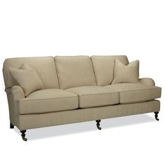 a beige couch with four pillows on it's back legs and arms, against a white background