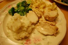 a plate with chicken, pasta and broccoli on it sitting on a table