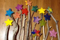 several wooden sticks with colorful stars on them sitting on a table next to a wall