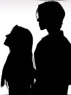 two people standing next to each other in silhouette