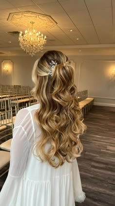 the back of a woman's head with long blonde hair in a wedding dress