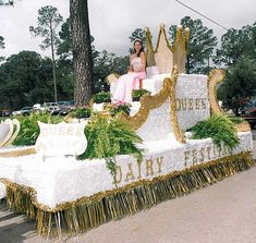 a woman sitting on top of a float in the street