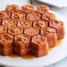 there are many pieces of cake on the plate with caramel sauce around it and one piece has been cut into cubes