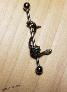 a black ball and chain on a wooden surface with an arrow charm attached to it