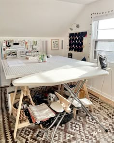 an ironing board sitting on top of a table in a room with lots of clutter