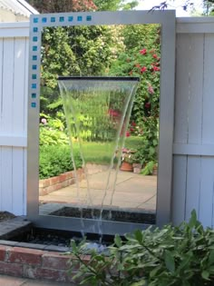 a water fountain in the middle of a garden