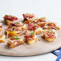 small appetizers are arranged on a wooden platter